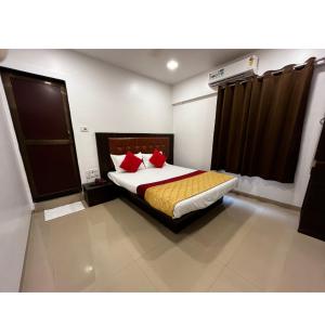 um quarto com uma cama com almofadas vermelhas em Hotel Borivali Executive - Near Borivali Railway Station em Mumbai