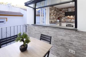 a balcony with a wooden table and a kitchen at El Monte in Cómpeta