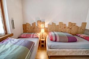 two twin beds in a room with wooden headboards at Casa Al Rin Ski Bike and Wellness in Valdidentro