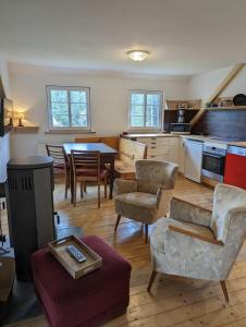 ein Wohnzimmer mit einem Tisch und Stühlen sowie eine Küche in der Unterkunft Landhaus Eilenberg Holzhau in Rechenberg-Bienenmühle