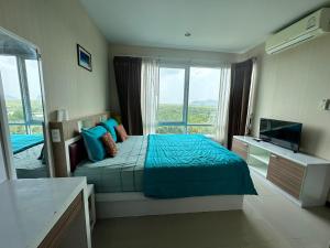 a bedroom with a bed and a large window at The Ozone Krabi Condotel in Krabi town