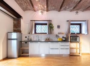 a kitchen with white cabinets and a wooden ceiling at Il Nido della Buonanotte 2 KIDS friendly in Verona
