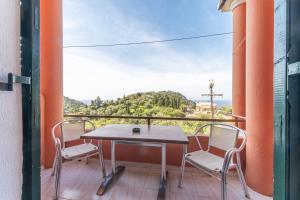 a table and chairs on a balcony with a view at Arianna apartment 10 in Paleokastritsa