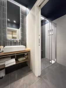 a bathroom with a shower and a sink and a mirror at 3L Luxury Rooms in La Spezia