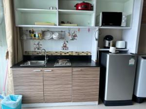 The Ozone Krabi Condotel في مينْغكرابي: مطبخ صغير مع مغسلة وثلاجة