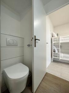 a white bathroom with a toilet and a closet at Les Tamaris - Studio with Sea View - Trouville-Sur-Mer in Trouville-sur-Mer