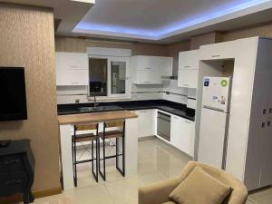 a kitchen with white cabinets and a refrigerator and a counter at Antalya liman Apartment 1+1 in Antalya