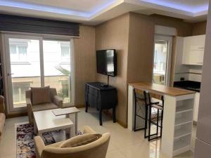 a living room with a tv and a couch and a table at Antalya liman Apartment 1+1 in Antalya