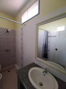 y baño con lavabo, espejo y ducha. en Metro Residence en Surin