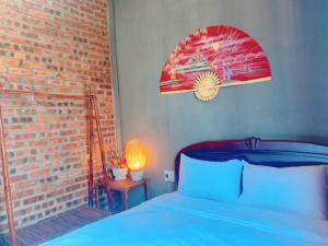 a bedroom with a blue bed and a brick wall at Sunshine villa thuan an in Hue