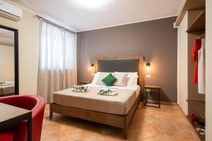 ein Schlafzimmer mit einem Bett und einem roten Stuhl in der Unterkunft La Ginestra in Fiore Camere in Sirolo