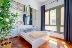 a bedroom with a white bed with blue pillows at Espectacular loft en centrico edificio singular in Manresa