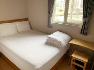 two beds in a small room with a window at XDZ Hotel in Taipei