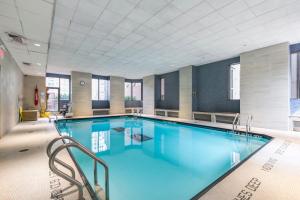 a large swimming pool with blue water in a building at Tribeca Studio w Great views Indoor pool NYC-109 in New York