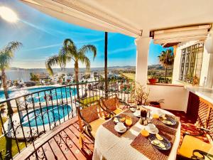 balcone con tavolo e vista sulla piscina di Luxury Puebla Aida with Golf & Sea View a Mijas Costa