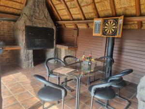 a patio with a table and chairs and a dartboard at Luxury Secured Apartment in Centurion