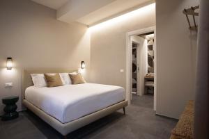 a bedroom with a white bed and a bathroom at 3L Luxury Rooms in La Spezia