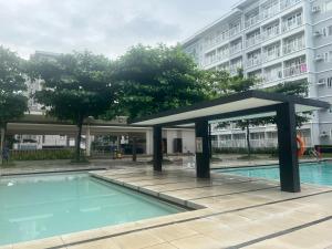 una piscina con un pabellón junto a un edificio en Inn the City, en Manila