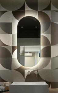 baño con espejo y lavabo en 3L Luxury Rooms, en La Spezia