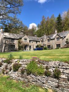 a large stone house with a stone wall at The Skreen in Builth Wells