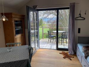 a room with a door open to a patio with a table at Bezauberndes Tiny House im Grünen in Breitbrunn am Chiemsee