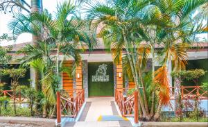 a hotel with palm trees in front of a building at Noni's Resort in Alitagtag