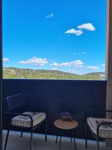einen Balkon mit 2 Stühlen und einem großen Fenster in der Unterkunft Apartman Suzi in Divčibare