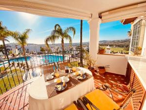 a balcony with a table and chairs and a pool at Luxury Puebla Aida with Golf & Sea View in Mijas Costa