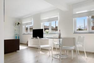 uma sala de estar branca com uma mesa e cadeiras em Appartamento Oliva Villa Arber em Maccagno Inferiore