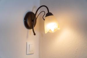 a lamp on a wall with a light on it at Arianna Studio 9 in Paleokastritsa