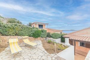 a patio with two chairs and a house at Villa Bella in Conca Verde