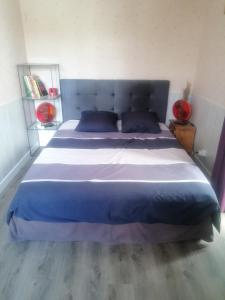 a bedroom with a large bed with blue pillows at Gaillarde in Brive-la-Gaillarde