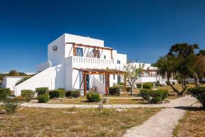 a white building with a staircase in front of it at Kiotari beach garden view-sea view in Kiotari