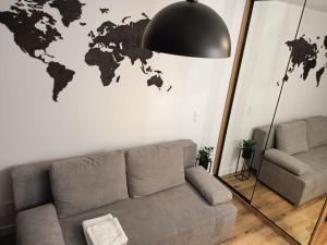 a living room with a couch and a world map on the wall at DROINVEST Apartament Jarzębinowa - Wrocław KRZYKI - PKP - UE in Wrocław