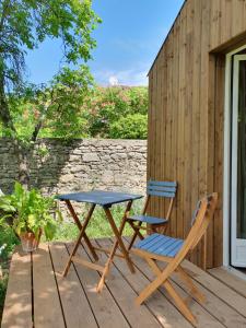 uma mesa de piquenique e duas cadeiras sentadas num deque em Studio en bois independant avec terrasse et jardin em Villevieille