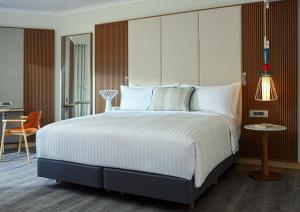 a bedroom with a large bed and a desk at Malta Marriott Resort & Spa in St. Julianʼs