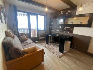 uma sala de estar com um sofá e uma secretária em Antarès Location Avoriaz em Avoriaz