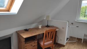 einen Holzschreibtisch in einem Zimmer mit einer Lampe und einem Stuhl in der Unterkunft Stiegenstübchen am Weinberg in Dresden