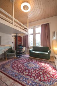 een woonkamer met een groene bank en een tapijt bij Kodikas Studio in Tampere