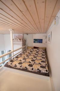 a bed in a room with a wooden ceiling at Kodikas Studio in Tampere