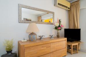 uno specchio su una parete sopra un comò con televisore di Apartment Sandra by the sea a El Campello