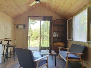 een kamer met stoelen, een tafel en een raam bij Studio en bois independant avec terrasse et jardin in Villevieille