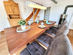 a wooden dining room table with two leather chairs at Ferienhaus Lucia in Hilzingen