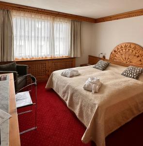 a hotel room with two beds with towels on them at Arsa Lodge Silvaplana in Silvaplana