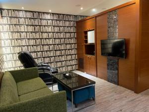 uma sala de estar com um sofá e uma televisão em Holland Hill Motel em Tainan