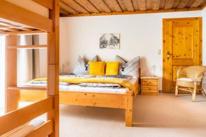 a bedroom with a bunk bed with yellow pillows at Unterwöhrlehen in Faistenau