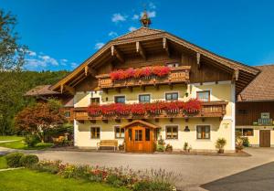 a large house with flowers on the top of it at Unterwöhrlehen in Faistenau