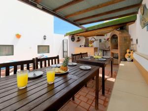 una mesa de madera con 2 vasos de zumo de naranja en Casa Chloe Tias, en Tías