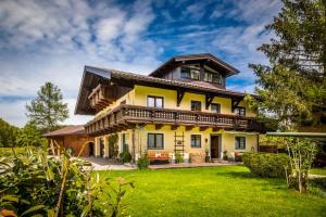 a large yellow house with a roof at Unterwöhrlehen in Faistenau