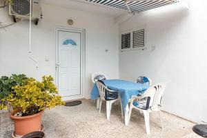 uma mesa azul e cadeiras num quarto branco em Solo Sole apartman 1- Meljine em Meljine